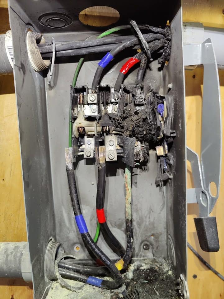 Inside of a burned out electrical disconnect box with charred wiring