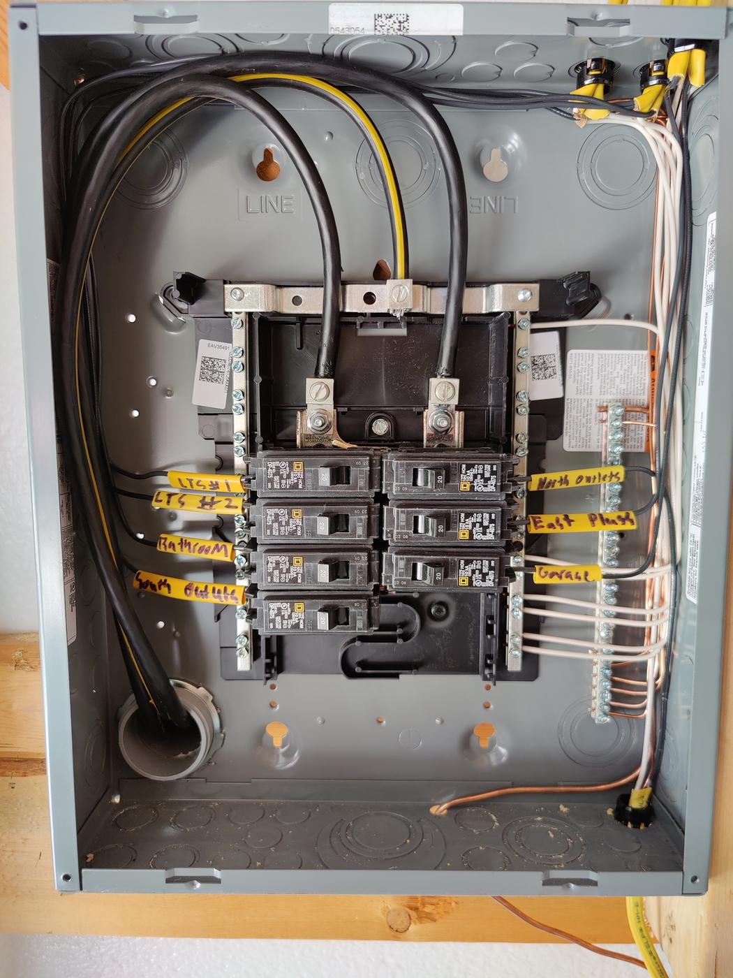 Open breaker panel with tidy wiring and hand-labeled circuit tags